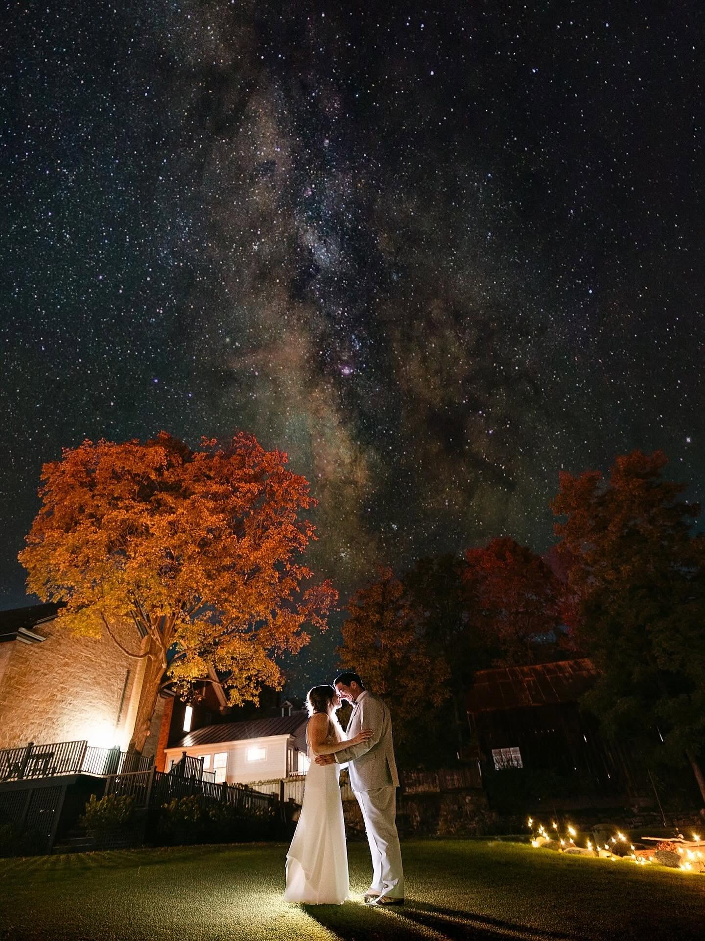 A bride and groom sharing a romantic moment under a brilliant starry night sky captured by a portrait photographer in Vermont.